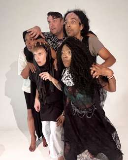 A group of five adults huddles together.